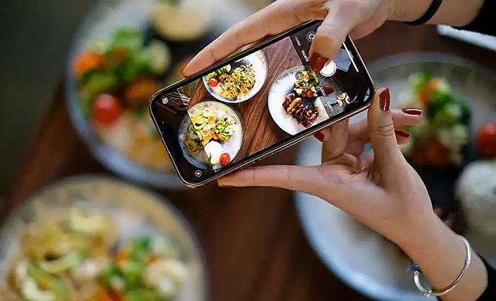 Yemek fotoğrafı çeken bir el